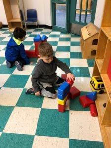 One boy builds with blocks during indoor recess.