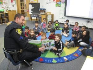 Officer Aaron reads to a class.
