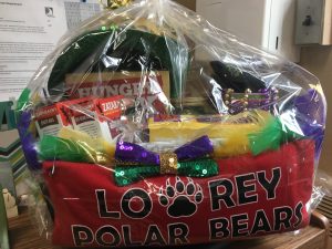 Lowrey Mardi Gras basket filled with different items. Red Lowrey shirt in front of basket!