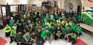 Students looking at the picture in Lowrey Schools Middle School lobby wearing green for Green Day