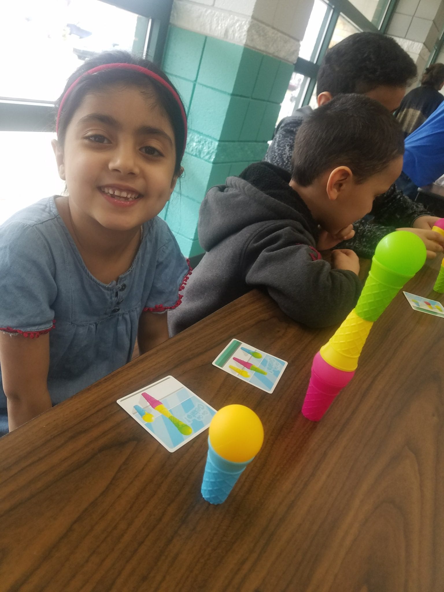 Student displaying her completed puzzle challenge using ice-cream scoops and cones
