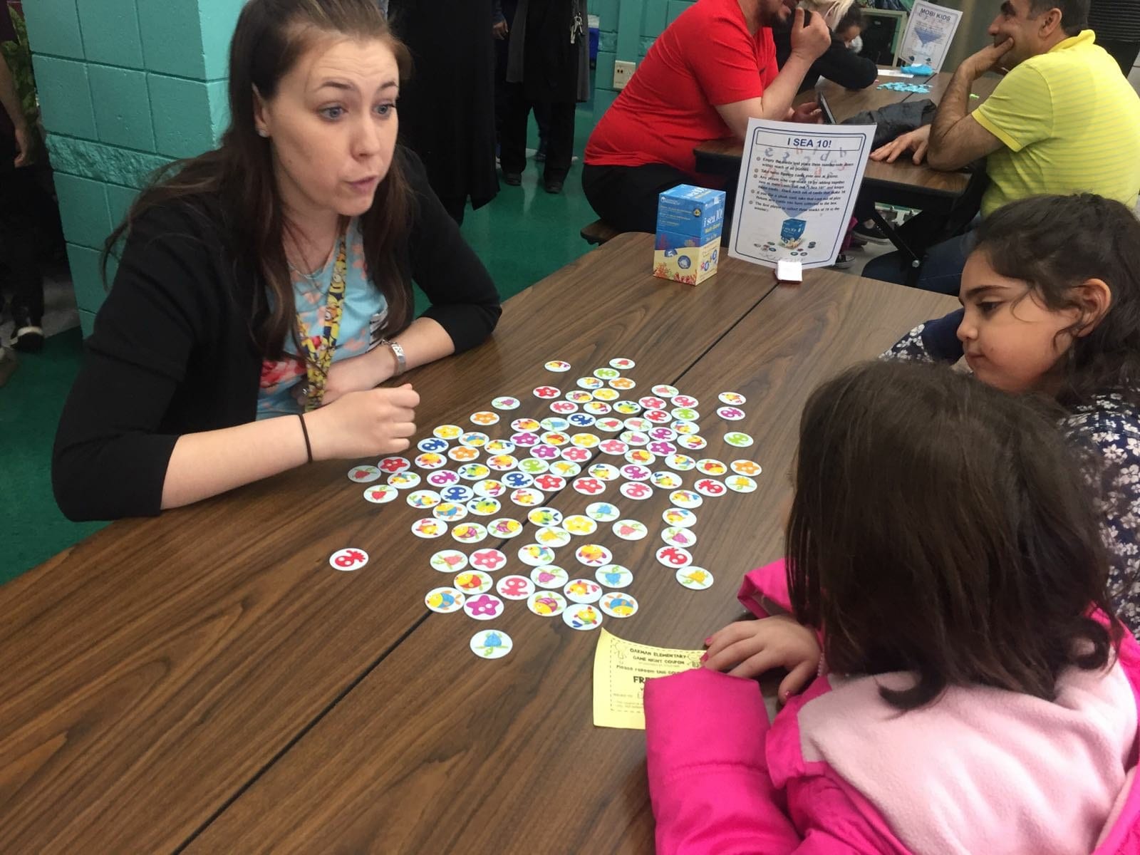 Two students playing a game with Ms. Peterson