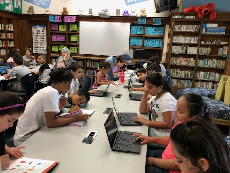 Students working in summer books and on chromebooks on our new program Exact Path