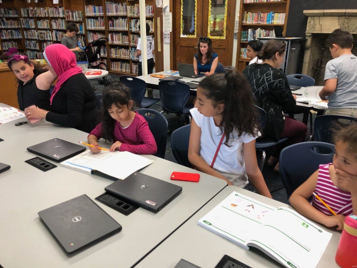 Students working in Media Center in the summer workbooks