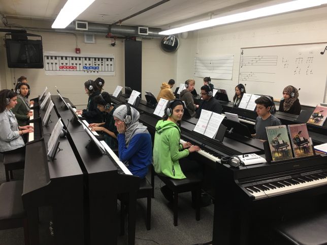 Students at DHS playing pianos in the piano lab