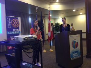 Students presenting at the Dearborn Rotary with a projector and podium