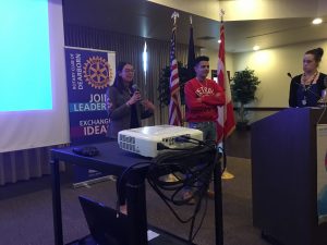 Students presenting at the Dearborn Rotary with a projector and podium