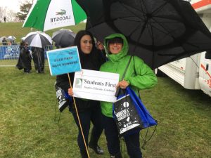 Two adults with rain gear and umbrellas