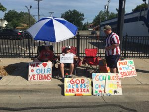 signs and students sitting at the parade. 