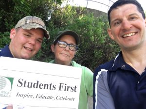 3 adults, the sign and a selfie in the shade. 