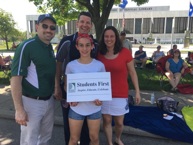 Trustee Thorpe and Family with the sign at the parade. 