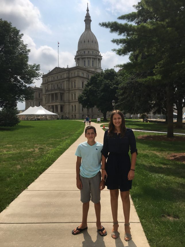 two children in Lansing in front of the capitol building