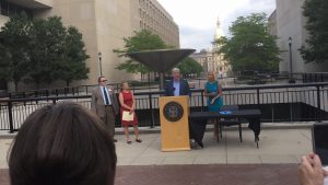 Governor and board members speaking in Lansing at the Brian Whiston fountain. 