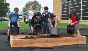 Smith Middle School students pour soil into one of the new planters at the school on Wednesday, Oct. 3, 2018.  The food and flower garden is part of a grant the district and its partners received to encourage healthy lifestyles in students.