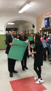 Principal Younes and students at Lowry Present Dr. maleyko with a special Sign