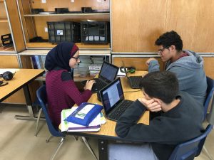 3 students working in a group on computers