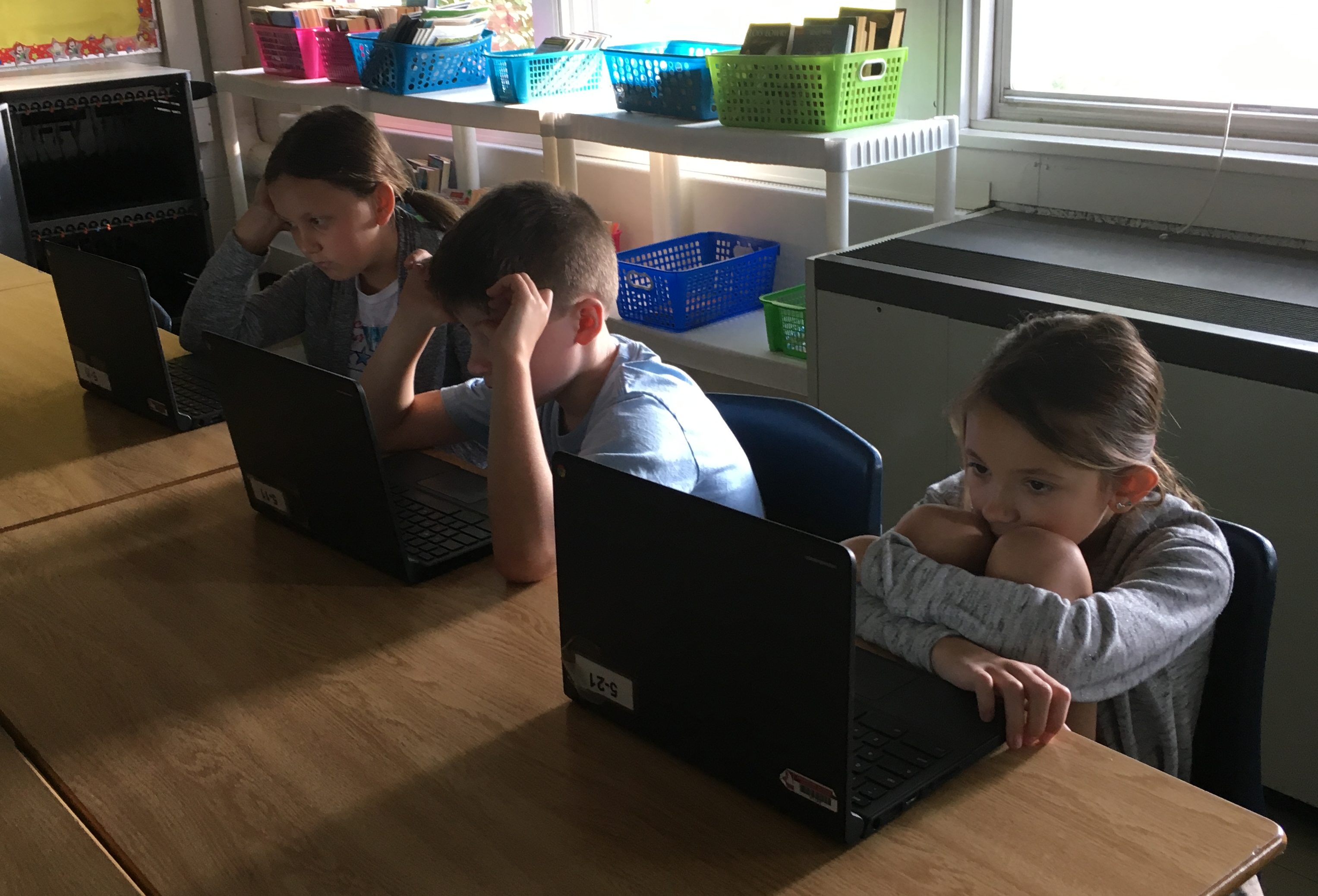 3 students read peer papers on their computer