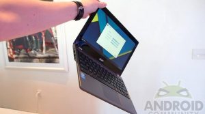 chromebook being held by one hand at the top of the screen