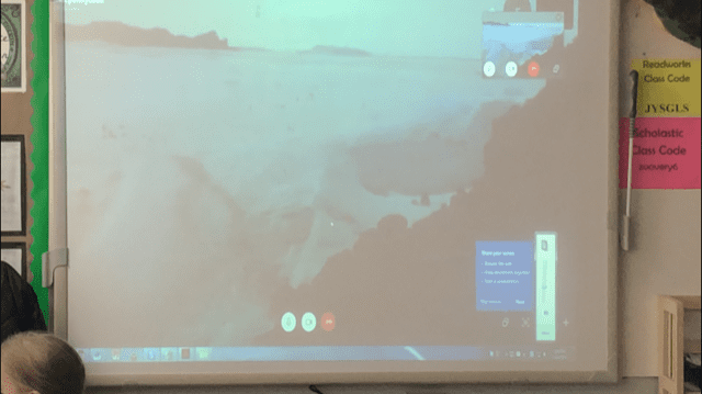 view of the ocean from antarctica projected on the board in front of a classroom