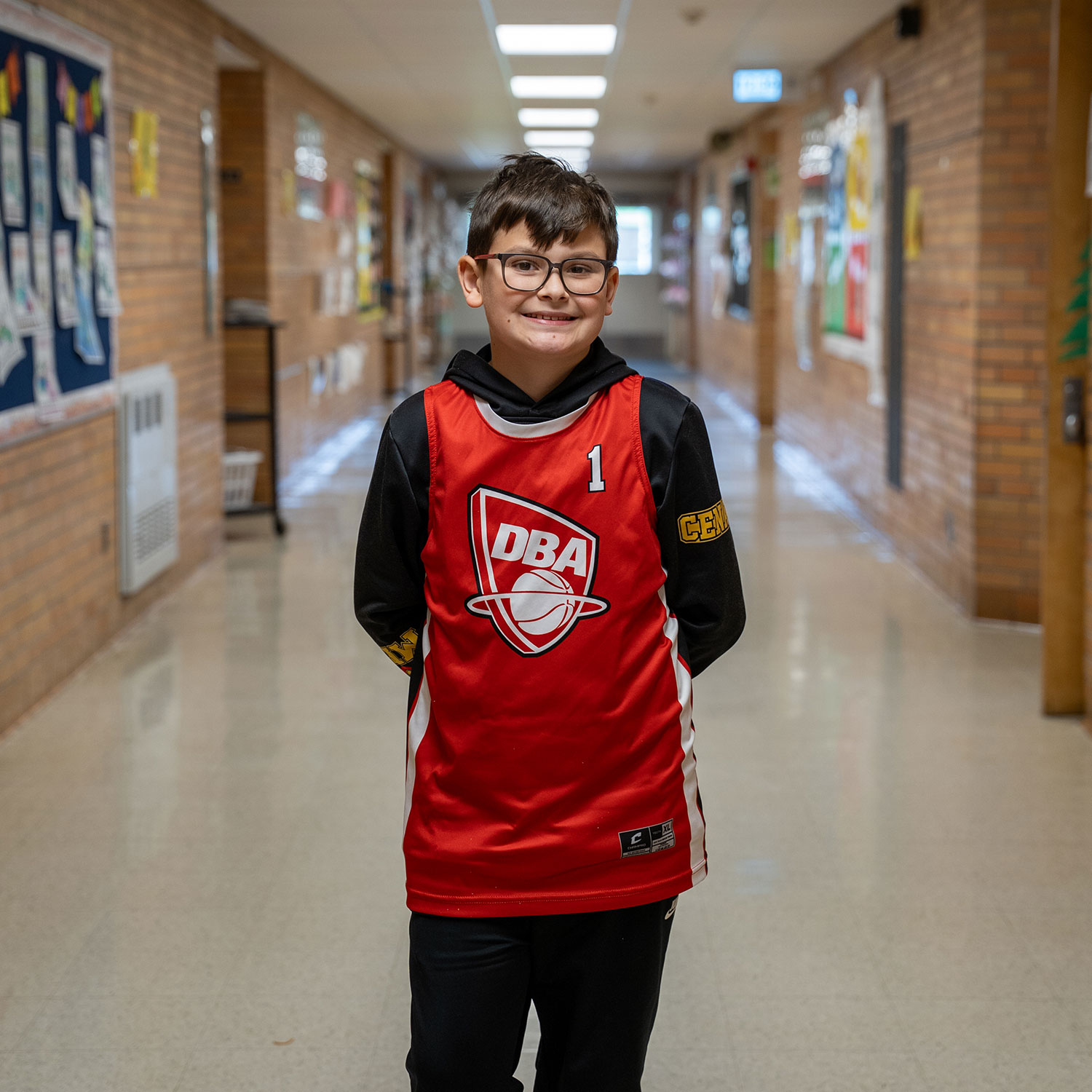 4th grade student standing in school hallway