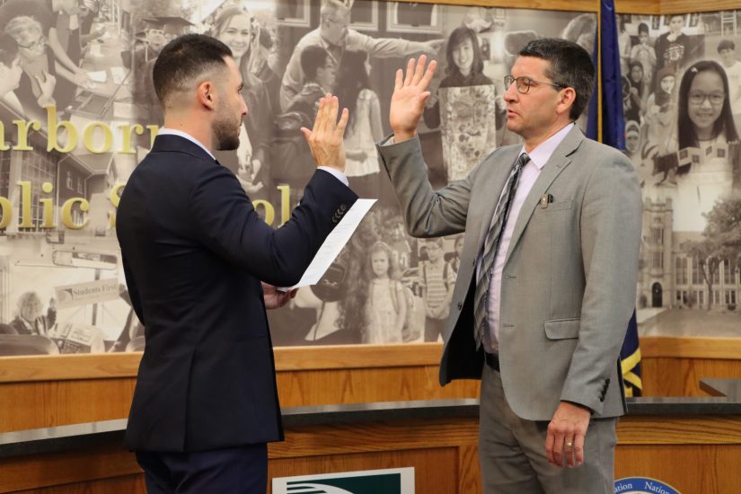Glenn Maleyko raises his right hand as he takes the oath of office administered by Dearborn Mayor Abduallah Hammoud.