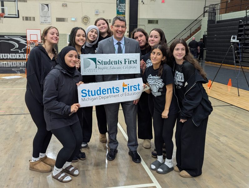 Superintendent Maleyko and a group of students hold signs for Dearborn Public Schools and the Michigan Department of Education.