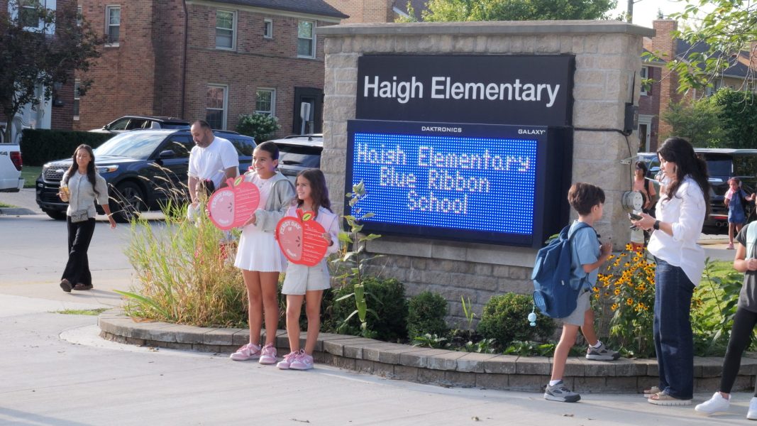 Two Haigh students pose in front of the school sign for first day of school photos.