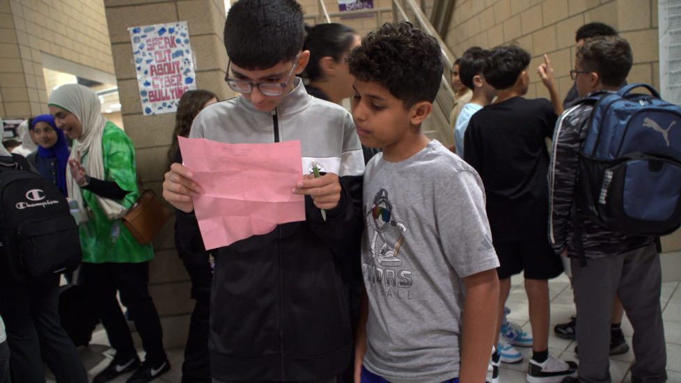 Two middle school students look over a class schedule on the first day of school in August 2025.