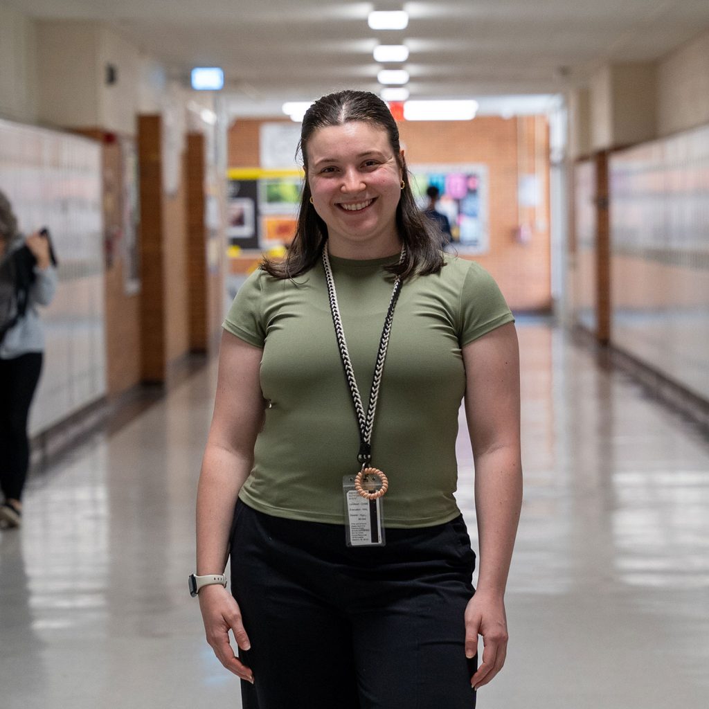 Female teacher posing in center of hallway