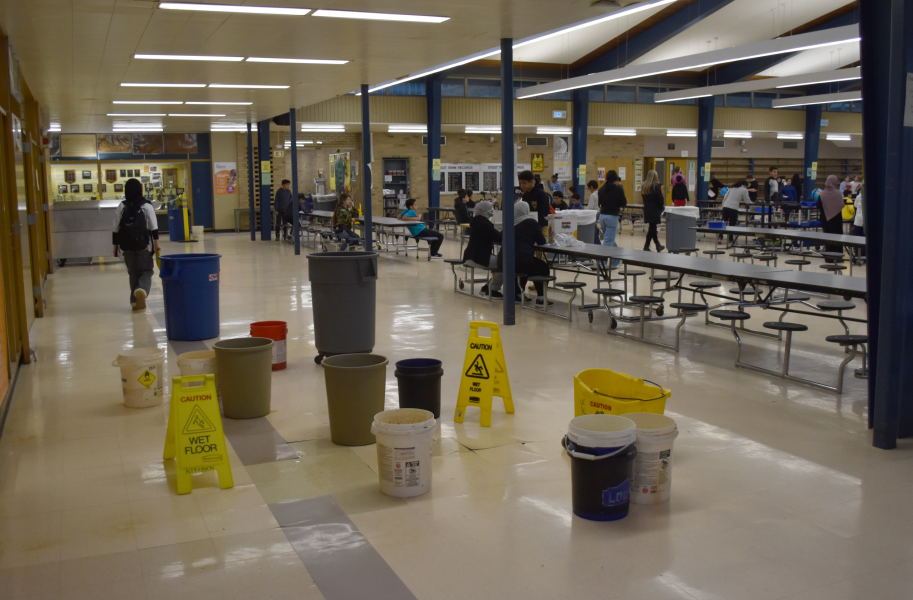 Buckets and slippery wet floor signs fill a section of the Stout cafeteria