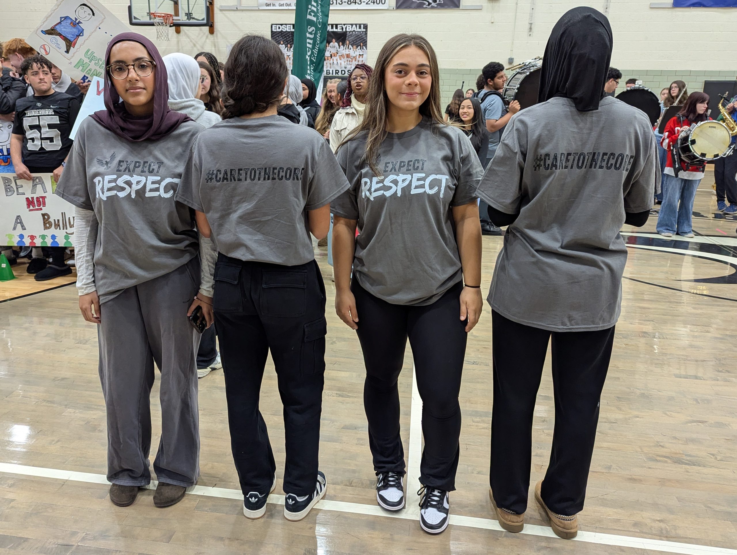 Four students show off their Care to the Core t-shirts